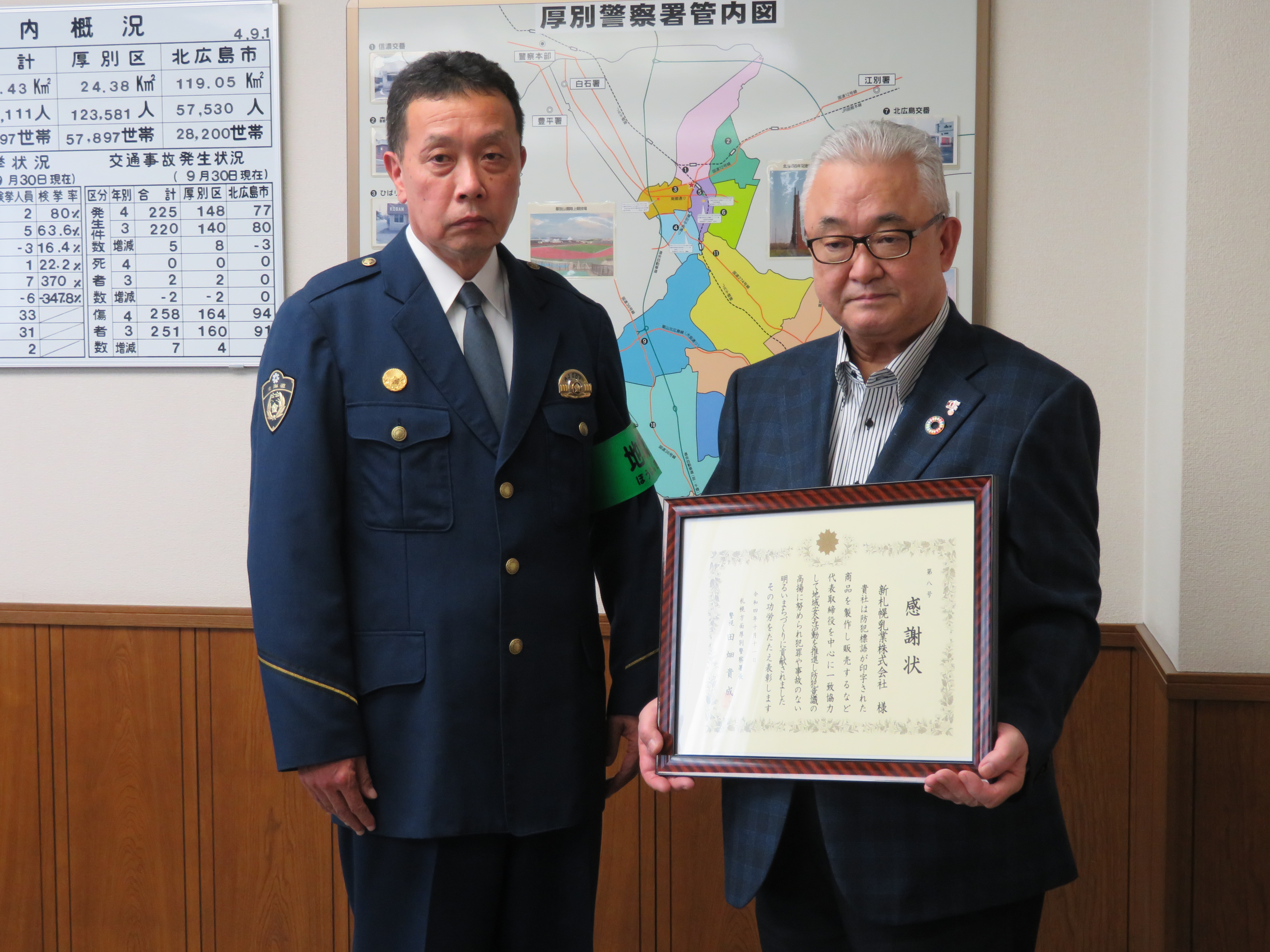 感謝状を持つ竹内久夫新札幌乳業社長（右）と田畑貴成厚別警察署長
