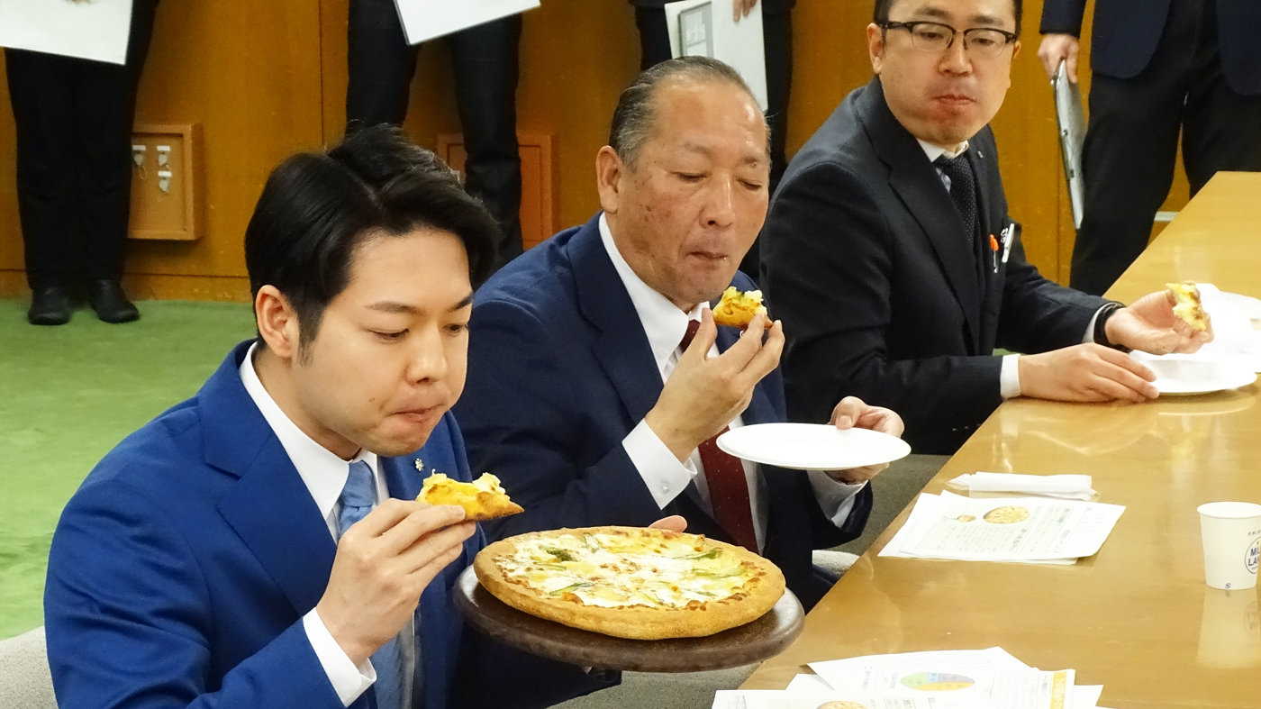 道産チーズを使ったピザをおいしそうに食べる鈴木知事（手前）や西川副会長（中央）ら