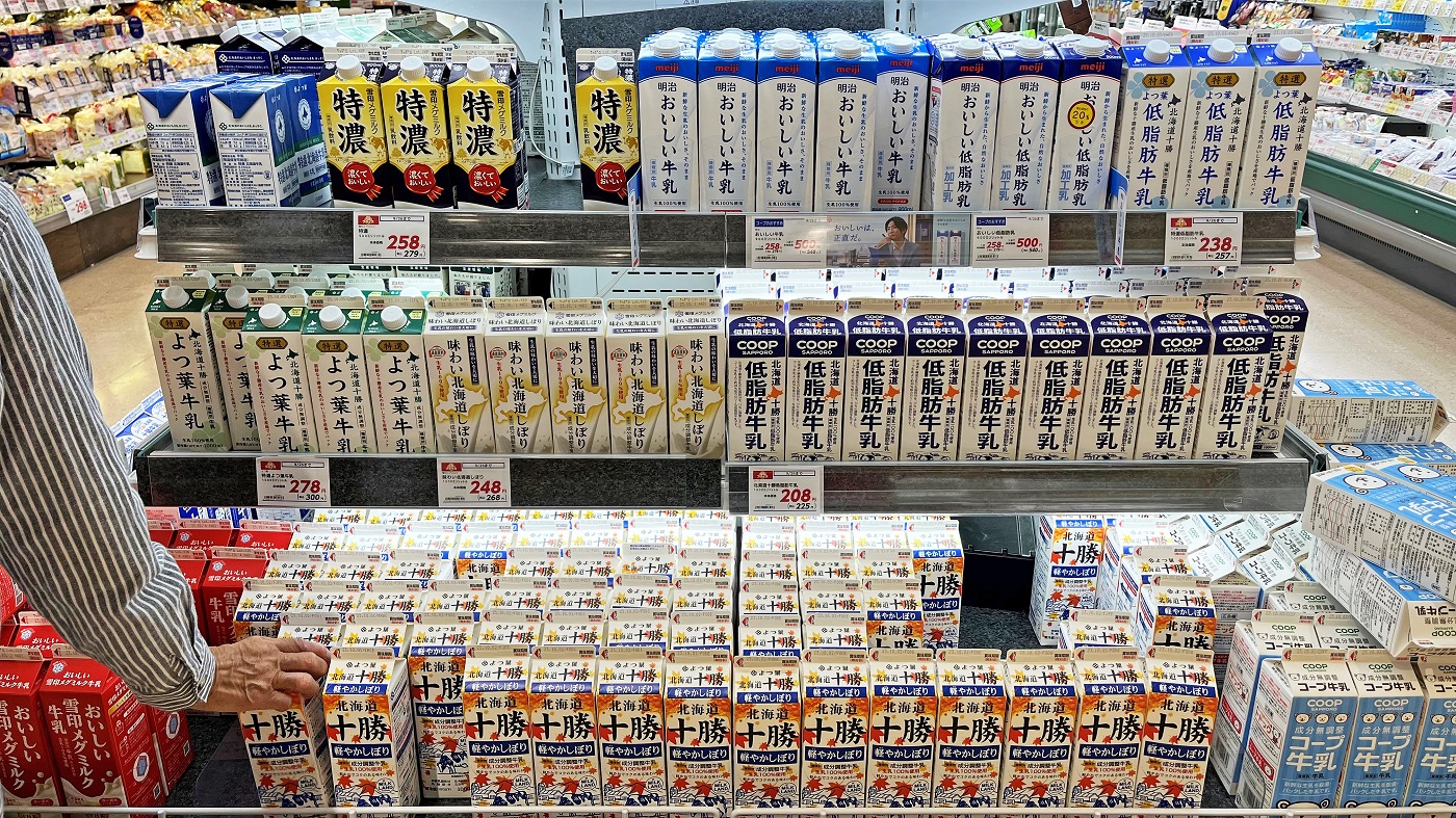 札幌市内の牛乳売り場。手頃な価格の成分調整牛乳や低脂肪牛乳が最下段や前面に並べられ、普通牛乳はPBを含めて両脇に寄せられている（9月下旬にコープさっぽろで撮影）