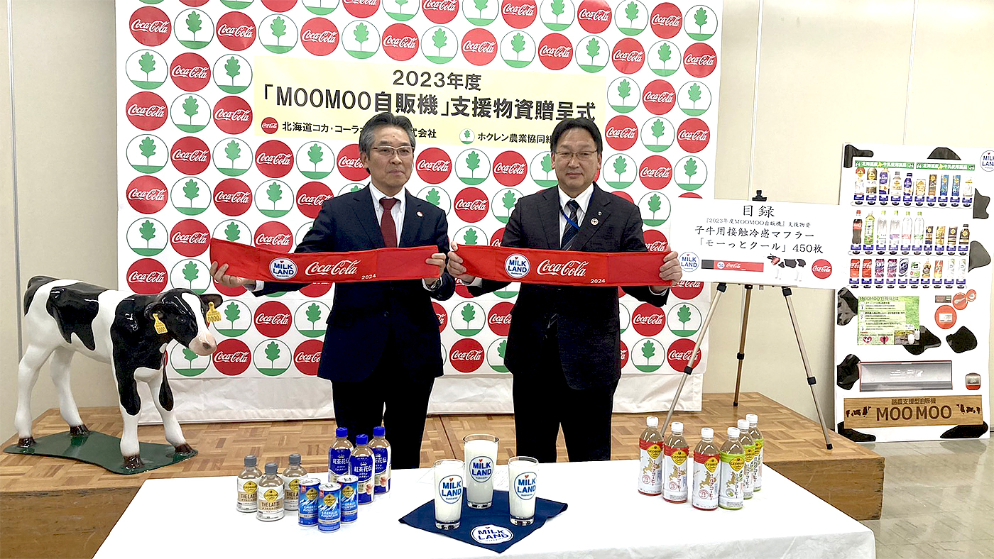 酪農家支援物資「モーっとクール」を手にする北海道コカ・コーラボトリングの酒寄正太社長（左）とホクレンの徳田善一副会長