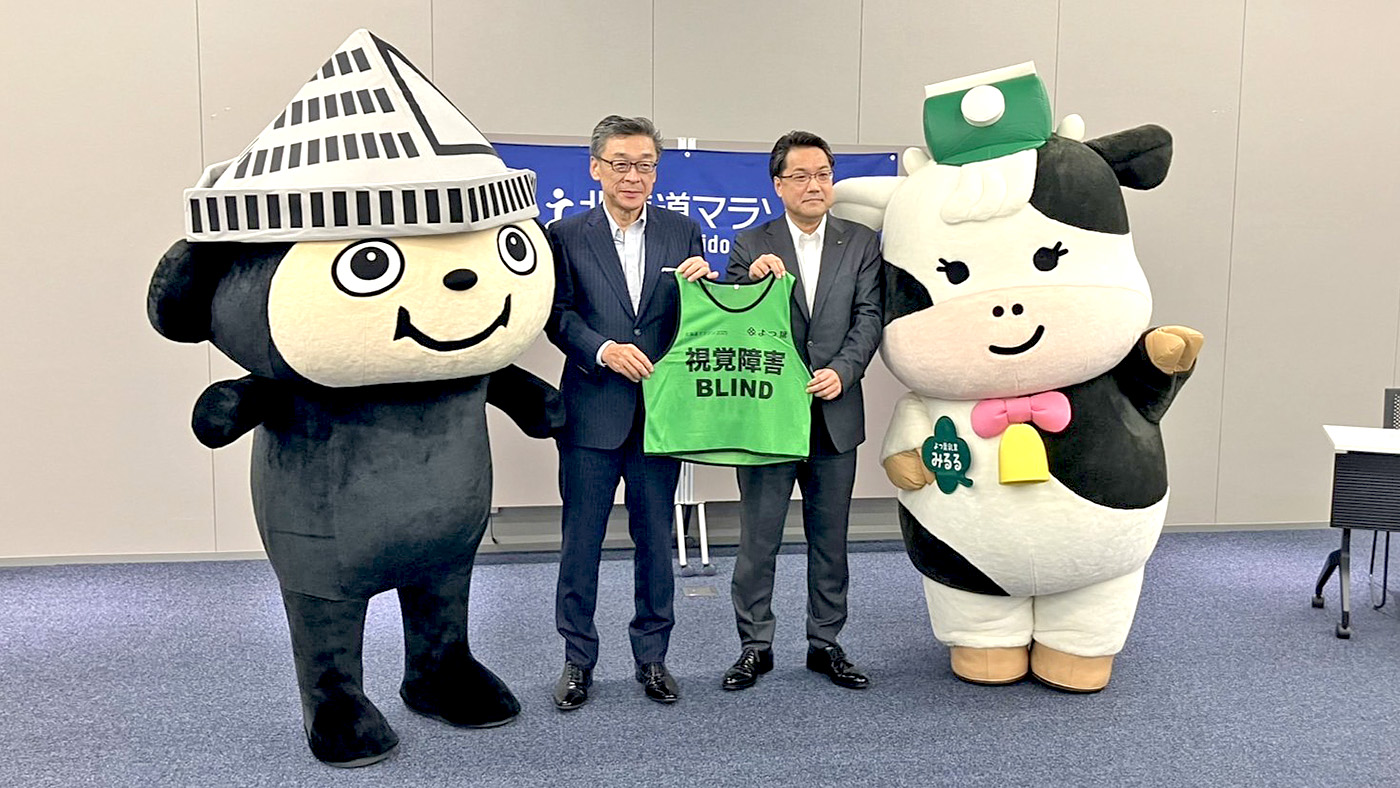 ビブスを手渡すよつ葉の西山常務（中央右）と北海道マラソン2025組織委員会の惣田副実行委員長