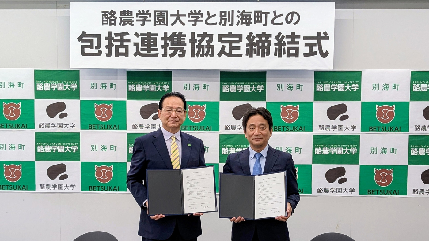 協定書を手にする曽根興三別海町長(左)と酪農学園大学の岩野英知学長