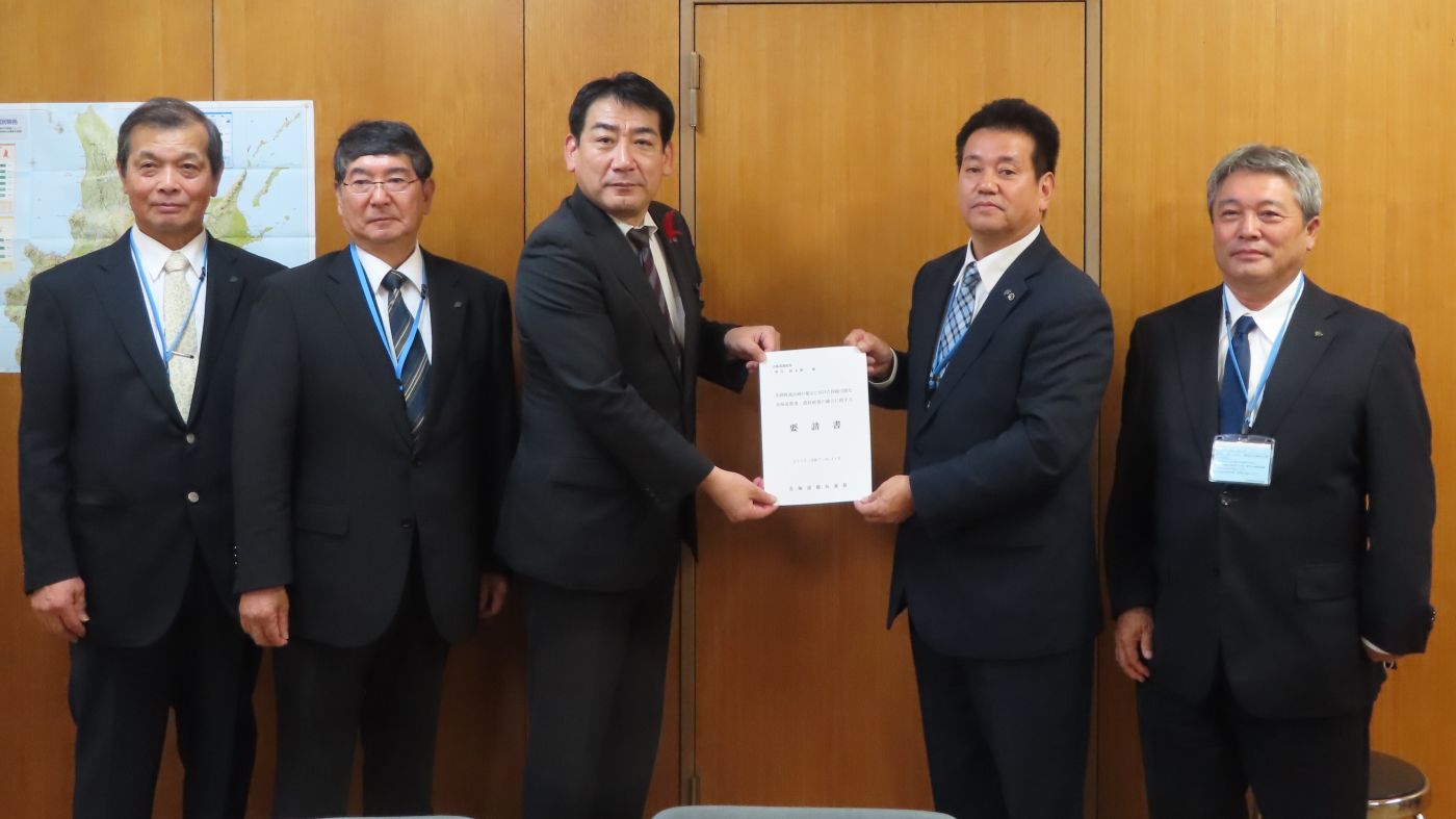 中原委員長（右から2人目）が鈴木農政部長に要請書を手交