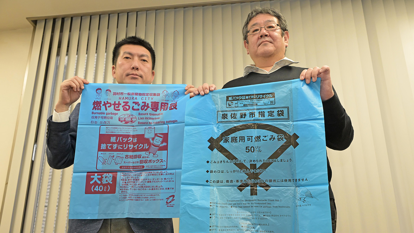 リサイクルを呼びかけた啓発ごみ袋を手にする伊藤忍常務（右）と山田幸宏事務局長
