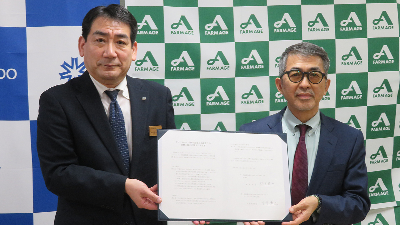 協定書を手にするファームエイジの小谷栄二代表（右）と鈴木賢一北海道農政部長