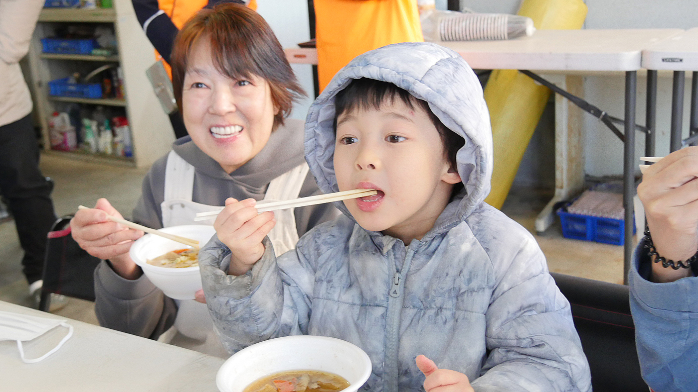 ぬくぬくオープンの日、豚汁を食べる子＝川和ミルク提供