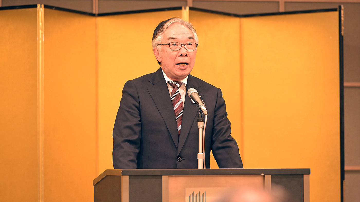 あいさつする八尾文二郎委員長