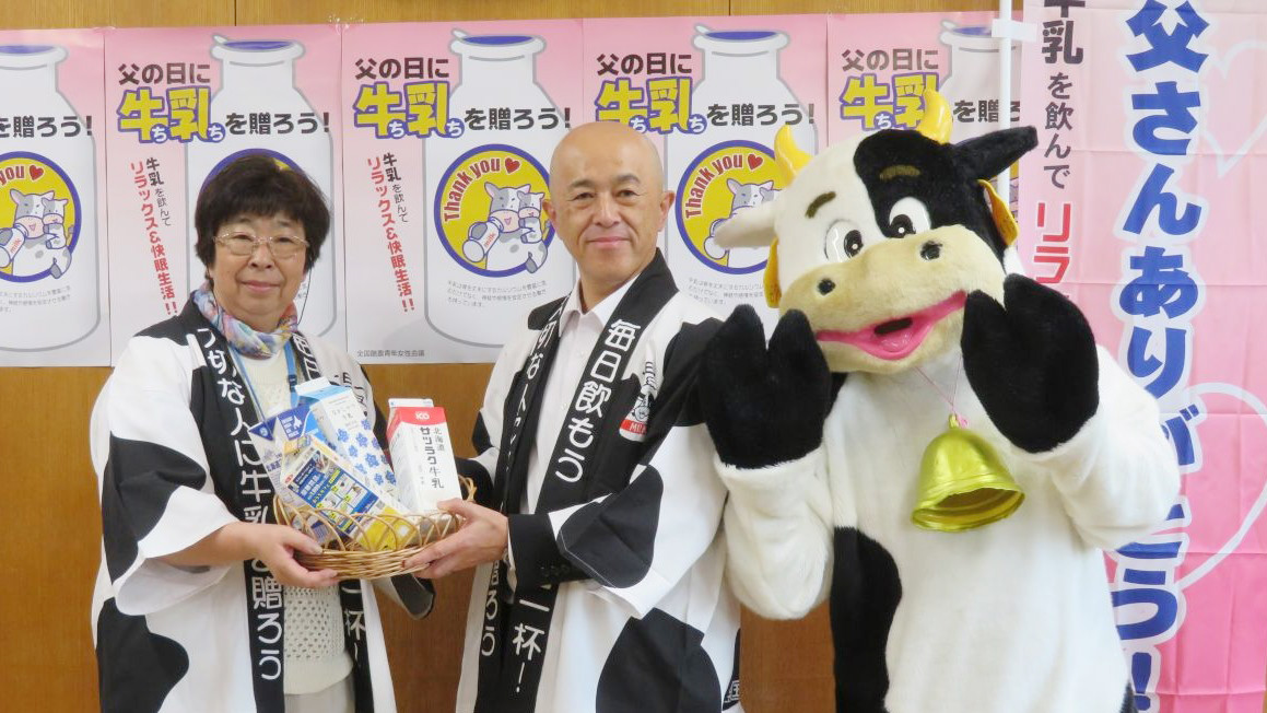 加納孝之副知事（中央）に道産牛乳を手渡す道酪青女の遠藤裕子委員長（左）