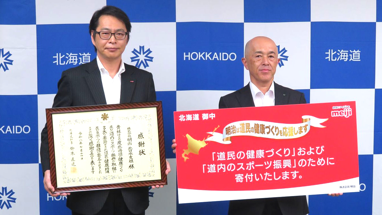 感謝状を手にする明治北日本支社の樋口靖夫支社長（左）と目録を掲げる加納孝之副知事
