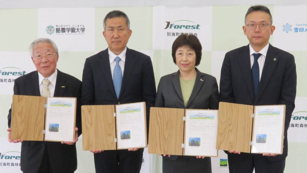 締結書を手にする雪印メグミルクの畑本二美常務（中央右）と酪農学園の髙島英也理事長（中央左）、農林中央金庫の尾崎太郎専務（右端）、別海町森林組合の池田實組合長
