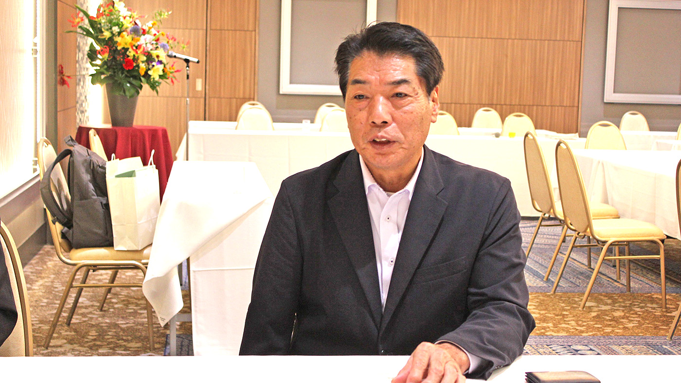 記者の質問に答える高橋秀行会長