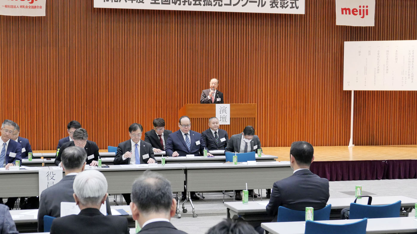 挨拶する渡辺ノボル会長（壇上）